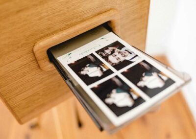 Sofortbilder kommen aus einem Fotoautomat aus Holz